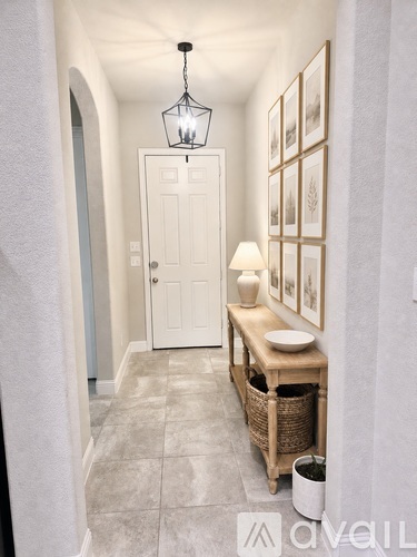 A hallway with a white door and a light hanging from the ceiling.