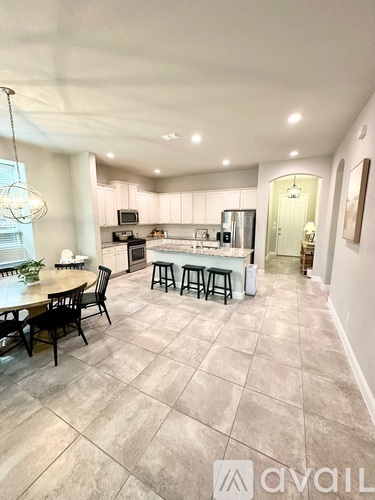 A modern kitchen with a dining table and chairs.