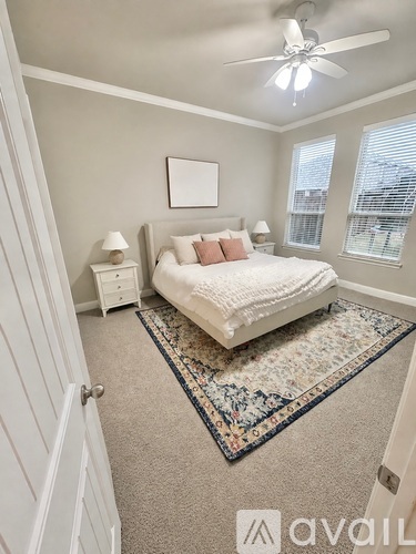 A bedroom with a bed, nightstand, and a ceiling fan.