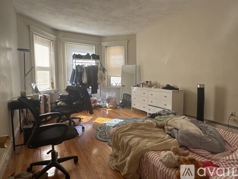 A room with a bed, desk, and chair.