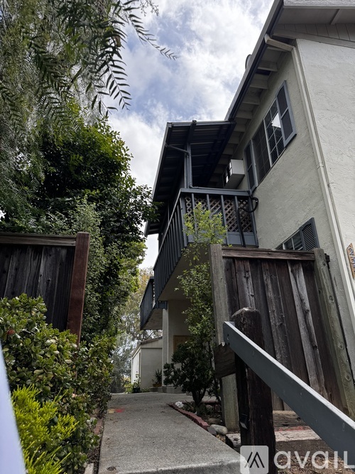 A white house with a balcony and a wooden fence.
