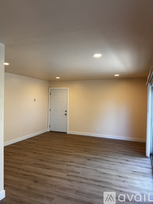 A room with wooden flooring and a white door.