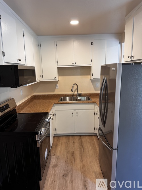 A kitchen with white cabinets and a black stove top oven.
