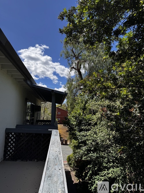 A house with a balcony and trees in the background.