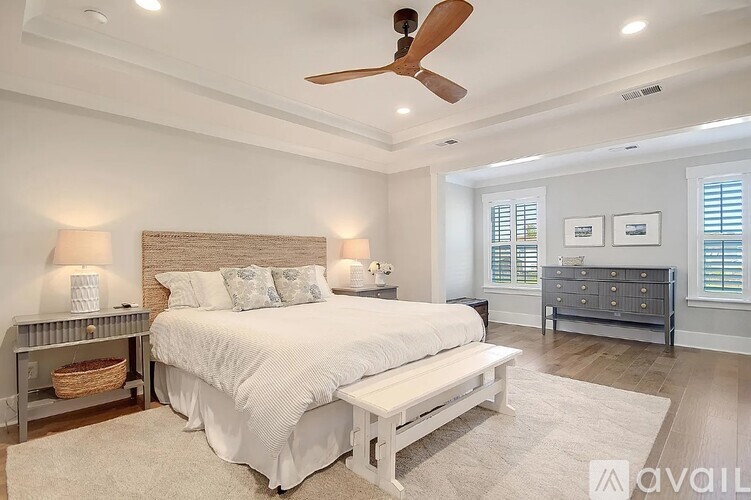 A bedroom with a large bed and a ceiling fan.