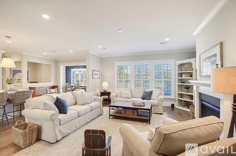 A living room with a white couch and a fireplace.