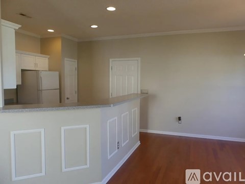 A kitchen with white cabinets and a countertop is available for rent.