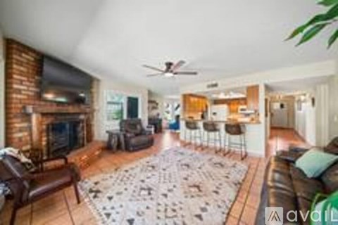 A living room with a fireplace and a rug on the floor.