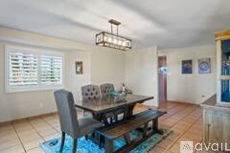 A dining room with a wooden table and chairs.