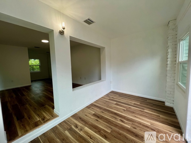 A room with wooden flooring and white walls.