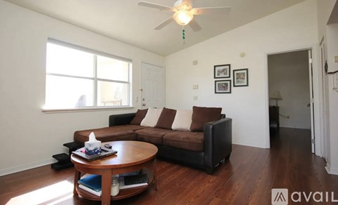 A living room with a brown couch and a wooden coffee table.