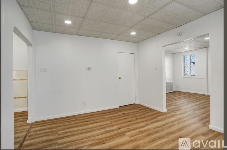 A room with wooden flooring and white walls.
