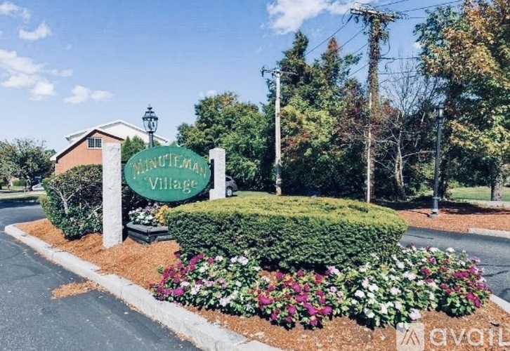 A sign for Minutema's Village stands in front of a building.