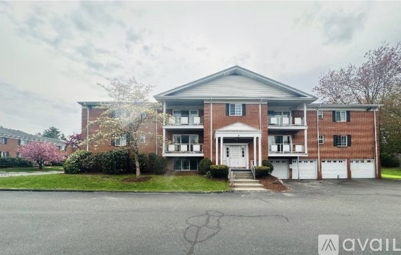 A two-story brick apartment building with a front entrance and a driveway.