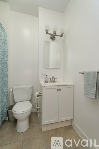 A white toilet sits next to a white cabinet in a bathroom.
