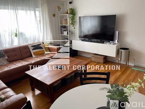 A living room with a brown leather couch and a wooden coffee table.