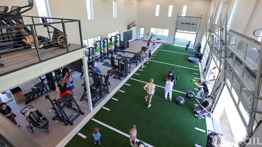 A gym with people exercising and fitness equipment.