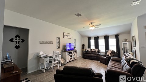 A living room with a brown couch and a television.