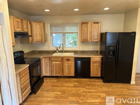 A kitchen with wooden cabinets and black appliances.