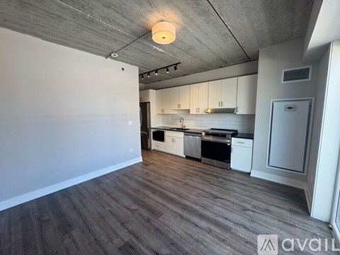 A kitchen with white cabinets and a wooden floor.