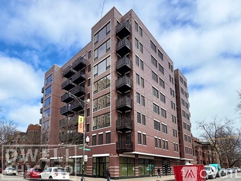 A red brick building with balconies on the second floor.