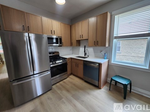 A kitchen with wooden cabinets and a stainless steel refrigerator.