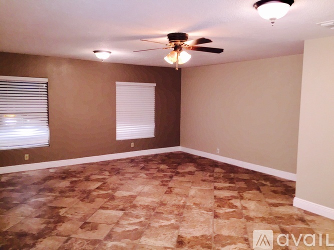 A room with a ceiling fan and tiled floor.