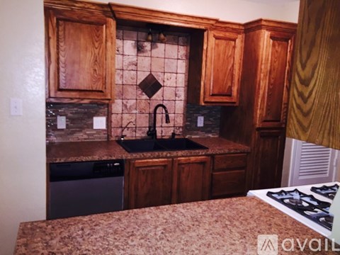 A kitchen with wooden cabinets and a black stove top.