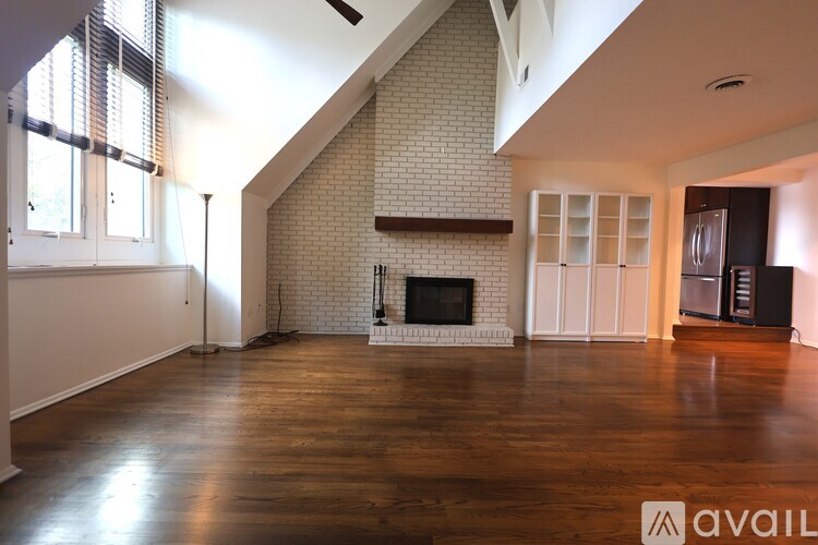 A spacious living room with a fireplace and wooden floors.