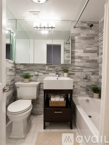 A bathroom with a toilet, sink, and mirror.