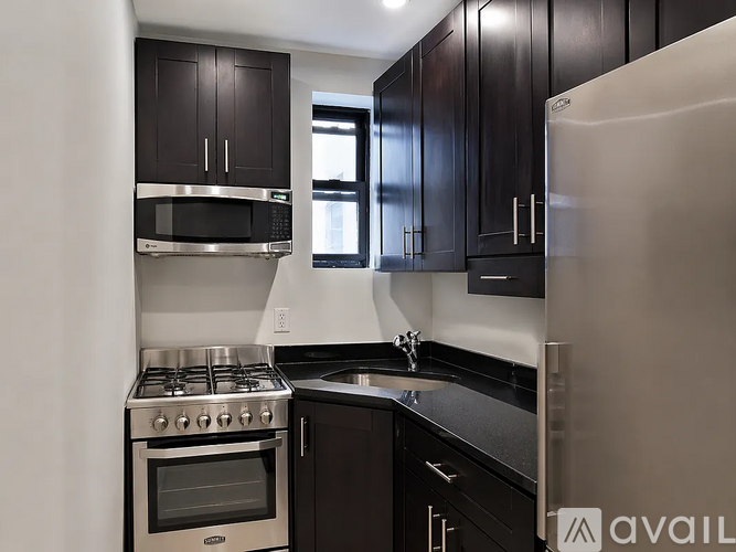 A kitchen with black cabinets and stainless steel appliances.