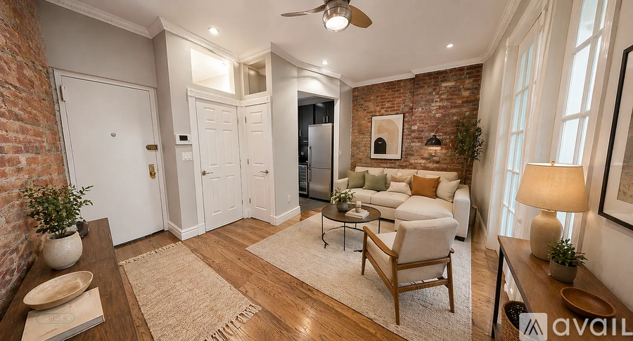 A living room with a brick wall and a ceiling fan.