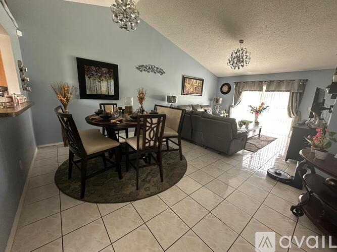A dining room with a table set for four and a couch.