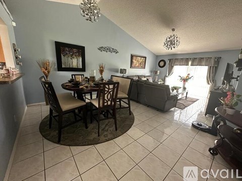 A dining room with a table set for four and a couch.