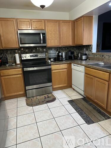 A kitchen with wooden cabinets and a black stove top oven.