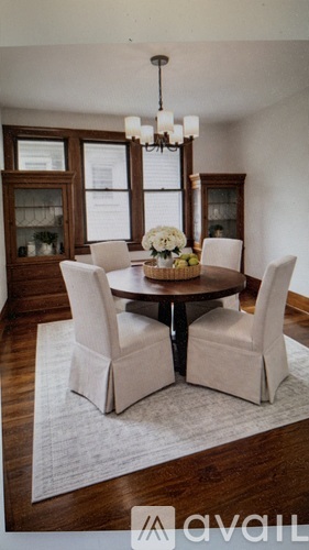 A dining room with a round table and chairs.