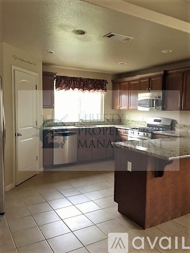 A kitchen with a granite countertop and a refrigerator.