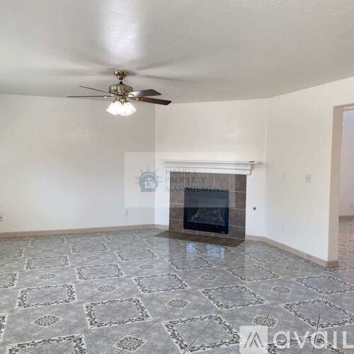 A living room with a fireplace and a ceiling fan.