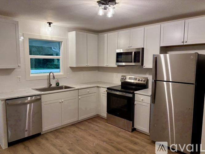 A kitchen with white cabinets and stainless steel appliances.