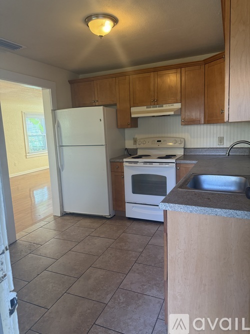 A kitchen with white appliances and wooden cabinets.