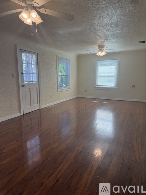 A room with wooden floors and a ceiling fan.