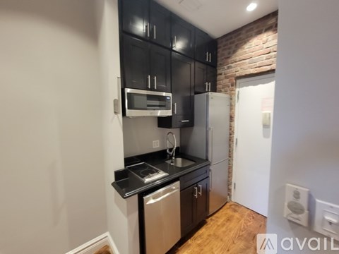 A kitchen with black cabinets and stainless steel appliances.