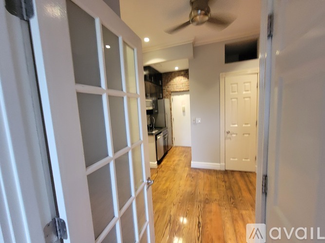 A room with a ceiling fan and a white door.