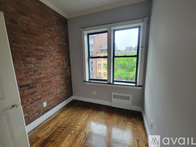 A room with a brick wall and wooden flooring.
