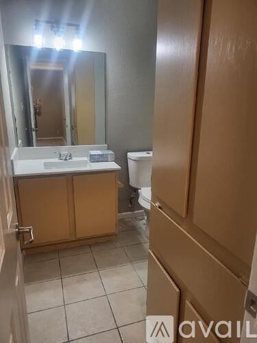 A bathroom with a sink, mirror, and toilet.