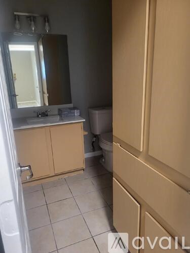 A bathroom with a toilet, sink, and mirror.