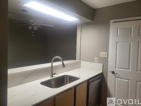 A kitchen with a sink and a fan.