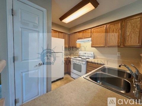 A kitchen with wooden cabinets and a white refrigerator.