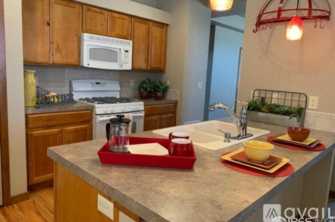 A kitchen with a white microwave above a stove and wooden cabinets.