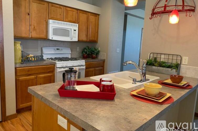 A kitchen with a white microwave above a stove and wooden cabinets.